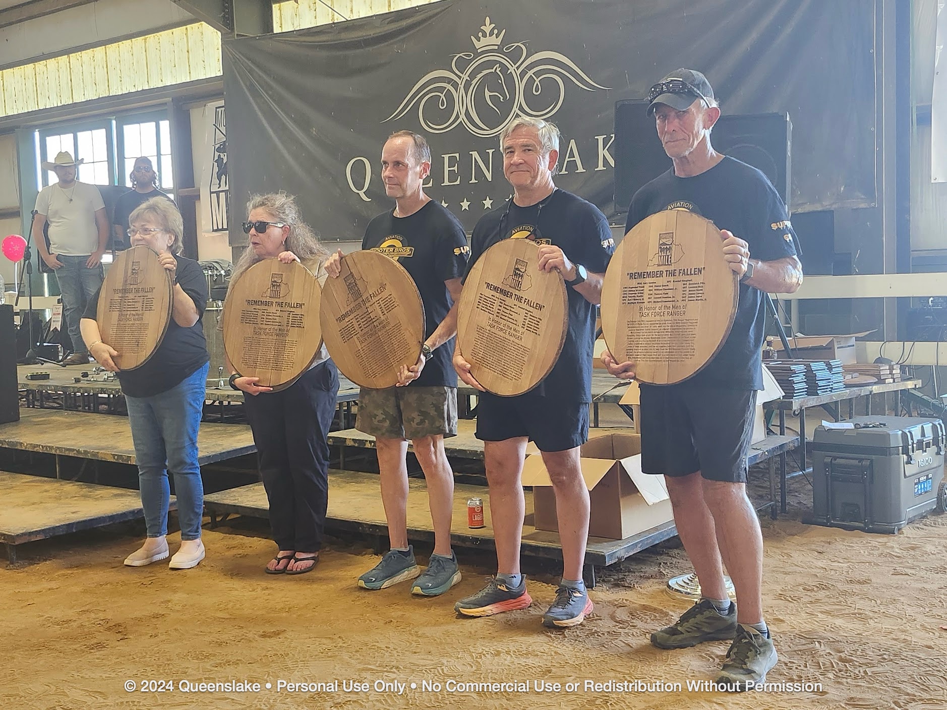 Pilots Dan Jollota, Mike Durant, and Jim Yacone with Gold Star wives Willa Frank and Shari Briley holding their engraved bourbon barrel heads.