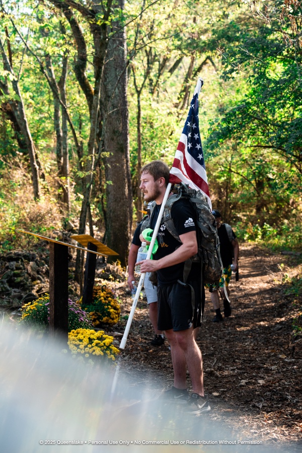 Rucker Carrying American Flag Pausing at Trail Memorial Station