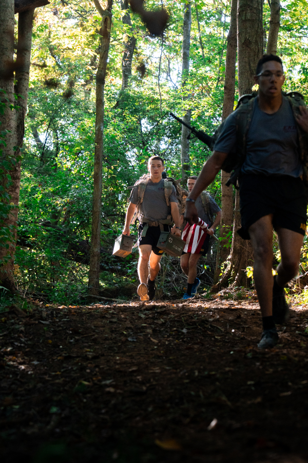 2026 Cadet Squad Marching Uphill Through Wooded Trail with Ammo Cans